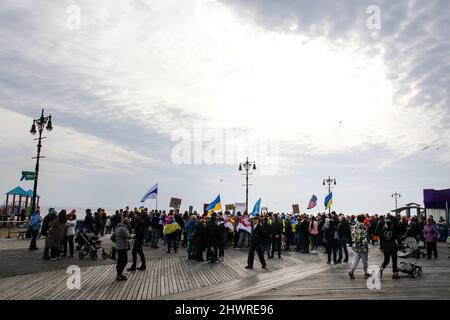 Bewohner von Brighton Beach treffen sich am 6. März 2022 zu einer Pro-Ukraine-Kundgebung auf dem Riegelmann Boardwalk und Brighton 6. in Brooklyn, New York, NY. Viele tragen die gelben und blauen Farben der ukrainischen Flagge, um ihre Unterstützung zu zeigen. Die größten ukrainisch-amerikanischen Gemeinden in New York City befinden sich in den Gebieten Brighton Beach und Sheepshead Bay in Brooklyn. Brighton Beach wurde aufgrund seiner Bevölkerung von Einwanderern aus der Ukraine, Russland und anderen ehemaligen sowjetischen Gebieten den Spitznamen Little Odessa erhalten. Russlands Angriff auf die Ukraine hat zu vielen Kundgebungen zur Unterstützung der Ukraine auf der ganzen Welt geführt. (Foto von Erica PR Stockfoto