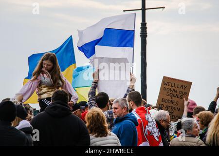 Bewohner von Brighton Beach treffen sich am 6. März 2022 zu einer Pro-Ukraine-Kundgebung auf dem Riegelmann Boardwalk und Brighton 6. in Brooklyn, New York, NY. Viele tragen die gelben und blauen Farben der ukrainischen Flagge, um ihre Unterstützung zu zeigen. Die größten ukrainisch-amerikanischen Gemeinden in New York City befinden sich in den Gebieten Brighton Beach und Sheepshead Bay in Brooklyn. Brighton Beach wurde aufgrund seiner Bevölkerung von Einwanderern aus der Ukraine, Russland und anderen ehemaligen sowjetischen Gebieten den Spitznamen Little Odessa erhalten. Russlands Angriff auf die Ukraine hat zu vielen Kundgebungen zur Unterstützung der Ukraine auf der ganzen Welt geführt. (Foto von Erica PR Stockfoto