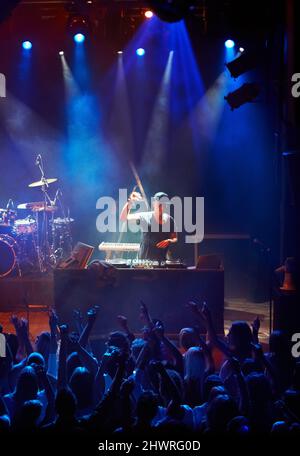 Ein DJ spielt sein Live-Set vor einer Gruppe schreiender Fans. Dieses Konzert wurde für den alleinigen Zweck dieses Fotoshootings mit 300 Modellen und 3 konzipiert Stockfoto