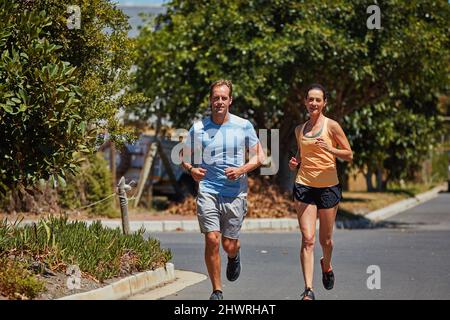 Das einzige schlechte Training ist das, was man nicht gemacht hat. Aufnahme eines glücklichen Paares, das in ihrer Nachbarschaft zusammen joggt. Stockfoto