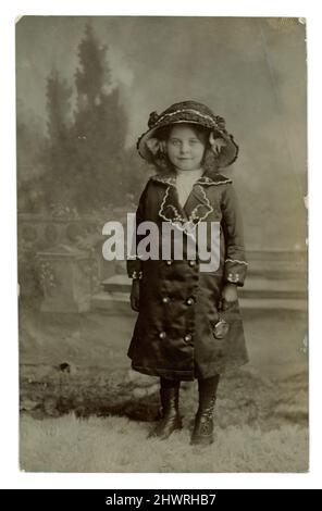 Originalpostkarte aus dem Jahr WW1 mit einem elegant gekleideten hübschen jungen Mädchen in einem großen Hut, einem passenden Mantel, Handschuhen und einer Handtasche. Fotografiert von Elizabeth Maria ‘Lizzie’ East, Park Lane Studio, Caemawr Road, Morriston, Swansea, Wales, vom Mai 14 1914 Stockfoto