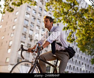 Ab, um auf seinen Rädern zu arbeiten. Aufnahme eines Geschäftsmannes, der mit seinem Fahrrad zur Arbeit pendelt. Stockfoto