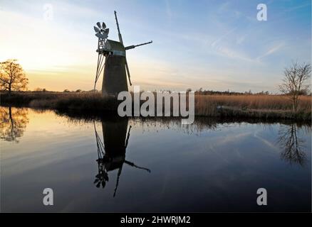 Eine Ansicht der Turf Fen Drainage Mill mit Reflexion durch den Fluss Ant auf den Norfolk Broads von How Hill, Ludham, Norfolk, England, Großbritannien. Stockfoto