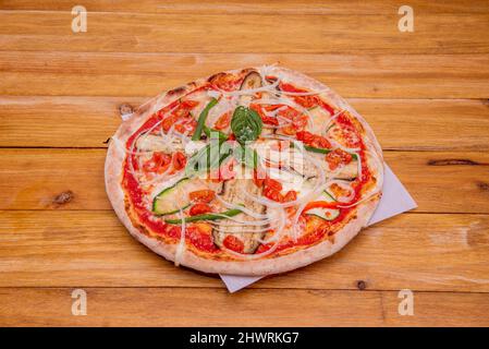 Gemüse-Pizza mit viel weißer Zwiebel, Zucchini, Auberginen, Kirschtomaten, Paprika und Mozzarella-Käse Stockfoto
