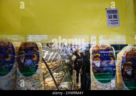 Bewohner und Geschäfte von Brighton Beach. Viele tragen die gelben und blauen Farben der ukrainischen Flagge, um ihre Unterstützung zu zeigen. Der Laden „Taste of Russia“ hat sein Zeichen entfernt und wird bald umbenannt. Die größten ukrainisch-amerikanischen Gemeinden in New York City befinden sich in den Gebieten Brighton Beach und Sheepshead Bay in Brooklyn. Brighton Beach wurde aufgrund seiner Bevölkerung von Einwanderern aus der Ukraine, Russland und anderen ehemaligen sowjetischen Gebieten den Spitznamen Little Odessa erhalten. Aufgenommen am 5. März 2022 in Brooklyn, New York. Menschen auf der ganzen Welt haben Schilder gepostet und ukrainische Flaggen aufgehängt, um die Ukraine zu unterstützen Stockfoto