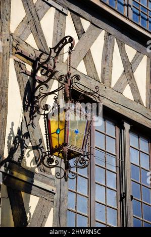 Antike Laterne, die auf einem Fachwerkhaus in der mittelalterlichen Stadt Auxerre, Burgund, Frankreich, hängt. Stockfoto