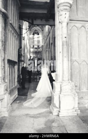 Verschwommenes Foto der Hochzeitszeremonie in der gotischen Kirche (Frankreich). Vater bringt Tochter zum Altar. Schwarz und Weiß. Stockfoto