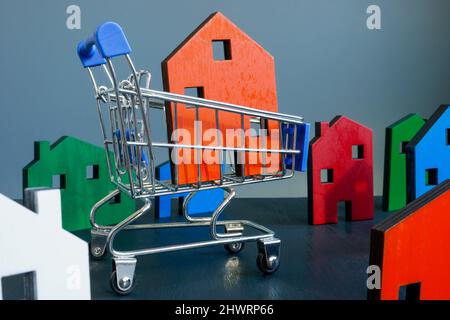 Kaufkonzept für Immobilien. Warenkorb und Modell des Hauses. Stockfoto