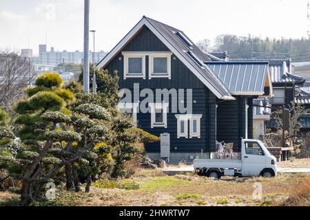 Kleiner japanischer Kei-Truck vor einem großen Landhaus Stockfoto