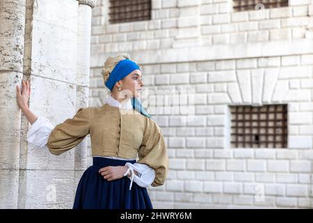Frau in einem wunderschönen, traditionellen venezianischen Kostüm und Maske, die sich wie Vermeer's Girl mit einem Perlenohrring auf dem Venedig-Karneval in venedig, Italien, ausgibt Stockfoto