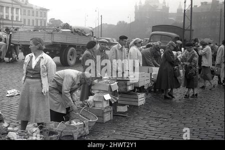1950s, historisch, auf dem marktplatz von helsinki, Verkäufer von Männern und Frauen, die draußen auf dem Kopfsteinpflaster stehen und ihre Erzeugnisse in offenen Kisten und Körben zeigen, South Harbour, Helsinki, Finnland. Stockfoto