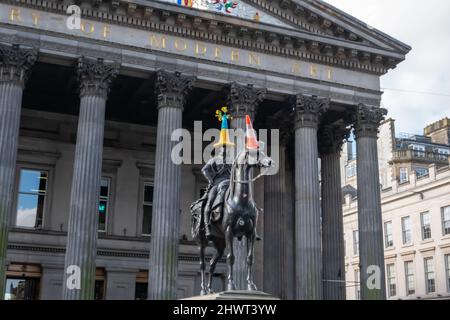 Glasgow, Schottland, Großbritannien. 7.. März 2022. Die Statue des Herzogs von Wellington erhält einen gestrickten Verkehrskegel in den blau-gelben Farben der ukrainischen Flagge, um die Unterstützung der Ukraine zu zeigen und gegen die russische Invasion zu protestieren. Kredit: Skully/Alamy Live Nachrichten Stockfoto