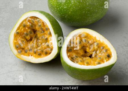 Frische, saftige ganze und halbierte Passionsfrucht aus nächster Nähe Stockfoto