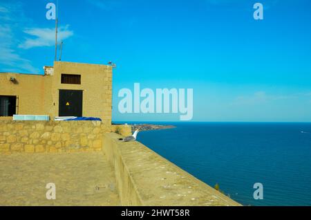 Alicante, Spanien - Juli 17 2019: Blick vom Castillo de Santa Bárbara auf das Mittelmeer vor Alicante. An der Burgmauer sitzt ein Seagu Stockfoto