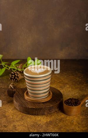 Ein aromatischer Kaffee, der frisch zum Ausgießen gemahlen wird, wird auf einem rustikalen Holztablett zu heißem oder kaltem schwarzen Kaffee Stockfoto