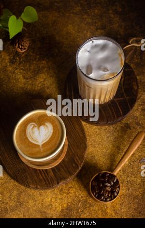 Ein aromatischer Kaffee, der frisch zum Ausgießen gemahlen wird, wird auf einem rustikalen Holztablett zu heißem oder kaltem schwarzen Kaffee Stockfoto