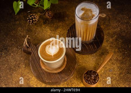 Ein aromatischer Kaffee, der frisch zum Ausgießen gemahlen wird, wird auf einem rustikalen Holztablett zu heißem oder kaltem schwarzen Kaffee Stockfoto