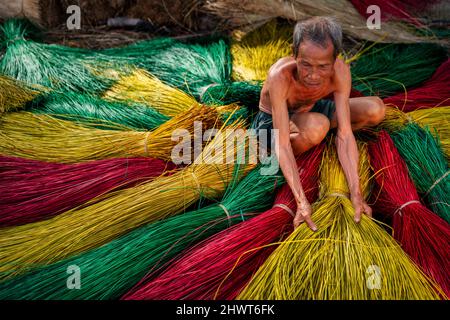 Vietnamesischer alter Handwerker trocknet traditionelle vietnamesische Matten im alten traditionellen Dorf in dinh Yen, dong thap, vietnam, Tradition Künstler Konzept, Stockfoto