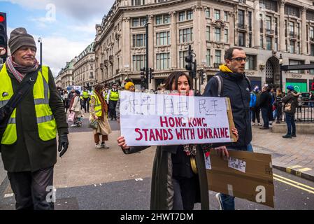 Frau mit dem Plakat „Hongkong steht mit der Ukraine“, „Stoppt den Krieg“, organisiert von Stop the war Coalition, London, Großbritannien, 6.. März 2022 Stockfoto