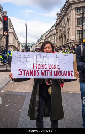 Frau mit dem Plakat „Hongkong steht mit der Ukraine“, „Stoppt den Krieg“, organisiert von Stop the war Coalition, London, Großbritannien, 6.. März 2022 Stockfoto