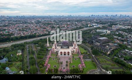 Luftaufnahme der At Tin Grand Mosque, wo diese Moschee die größte Moschee in Indonesien ist, die sich in Ost-Jakarta mit Blick auf die Berge befindet. Jakarta, Stockfoto