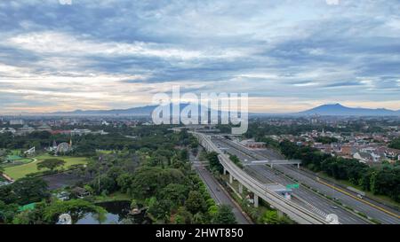 Luftaufnahme des ruhigen Verkehrs auf der Taman Mini Straße mit Blick auf die Berge während des Wochenendes in Jakarta Stadt. Jakarta, Indonesien, 8. März 2022 Stockfoto