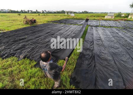 Vietnamesischer Arbeiter Färbet das Gewebe im traditionellen Prozess in Vietnam Stockfoto