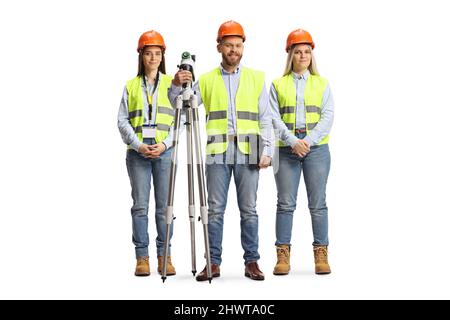 Team von jungen Geodätischen Vermessern, die mit einem auf weißem Hintergrund isolierten Messgerät posieren Stockfoto