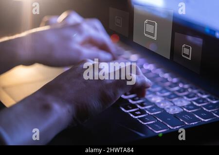Person arbeitet mit Dokumenten, Datendateien auf einem Laptop. Stockfoto