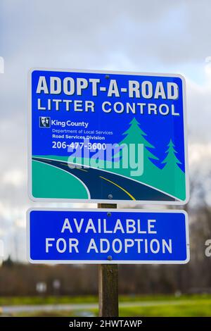 Fall City, WA, USA - 03. März 2022; Zeichen für Adopt a Road Litter Control in King County. Die Beschilderung ist mit einer Kontaktnummer verfügbar. Stockfoto