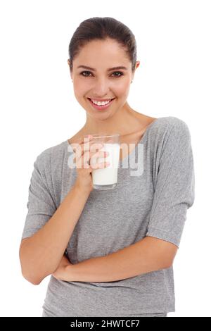 Milch für starke Zähne und Knochen. Kurzer Schuss einer attraktiven jungen Frau, die ein Glas Milch in der Hand hält. Stockfoto