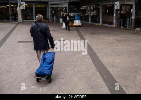 Eine Person wird mit einem Einkaufswagen gesehen, der in einen kommunalen Markt eintritt.die restriktiven Maßnahmen der EU als Reaktion auf die Invasion der Ukraine durch russische Truppen führen zu einem Anstieg der Preise für die grundlegendsten Lebensmittel wie Öl und Getreide. Stockfoto