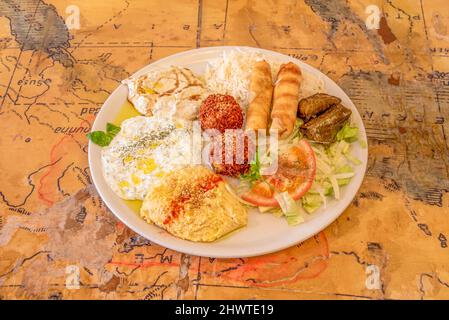 Türkisches Gemüsegericht mit Weinsarma, Joghurt mit Öl und Gewürzen, Hummus mit Paprika, Salat, Basmati-Reis und Falafelbällchen Stockfoto