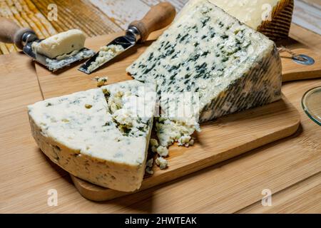 Zwei tolle Portionen Blauschimmelkäse aus verschiedenen Melken mit Käsemessern auf Bambusbrettern Stockfoto