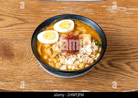 Einige gute Filets von köstlichem mariniertem Kabeljau, in einer Miso-Fischbrühe, gekochtem Ei, Mandeln, Pilzen und Reisnudeln Stockfoto