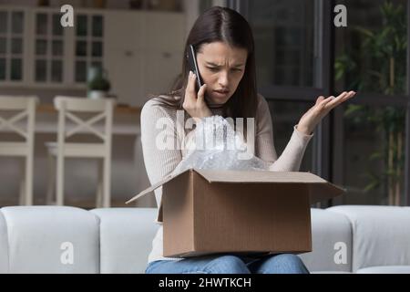 Frau äußert Beschwerden an Kunden Support-Services wegen beschädigtem Paket Stockfoto