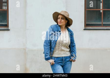Touristenfrau, die sich umsieht und posiert, während sie im Freien spazieren geht. Stockfoto