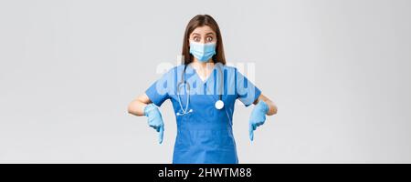 Covid-19, Prävention von Viren, Gesundheit, Gesundheitsarbeiter und Quarantänekonzept. Aufgeregt und interessiert Ärztin, Krankenschwester in blauen Peelings und medizinische Stockfoto