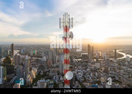 Telekommunikationsturm mit 5G Mobilfunkantenne auf Stadt Sonnenuntergang Hintergrund Stockfoto