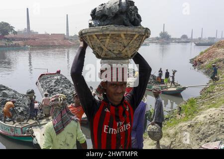 Keraniganj, Bangladesch. 07. März 2022. Bangladeschische Männer arbeiten auf einem Ziegelfeld in Keraniganj, in der Nähe von Dhaka, Bangladesch, 7. März 2022. Die Emission einer großen Menge von toxischen Elementen aus Ziegelöfen verursacht ernsthafte Gesundheitsgefahren für Arbeitnehmer und Menschen in der Umgebung, die am meisten unter Atemwegs- oder Hautproblemen leiden. Arbeiter in diesem Ziegelfeld verdienen weniger als $5 pro Tag. (Foto von Suvra Kanti das/Sipa USA) Quelle: SIPA USA/Alamy Live News Stockfoto