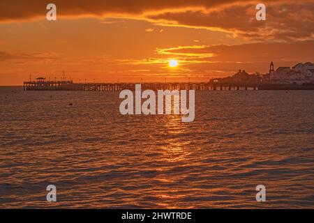 Ein wunderschöner goldener Sonnenaufgang am alten Pier von Swanage Stockfoto