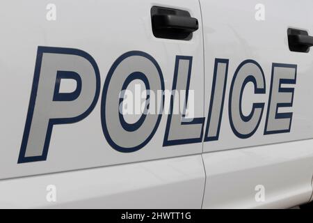 DIE POLIZEI druckte auf der Seite eines Polizeiwagens in fettem silbernen Text mit blauer Umrandung. Stockfoto