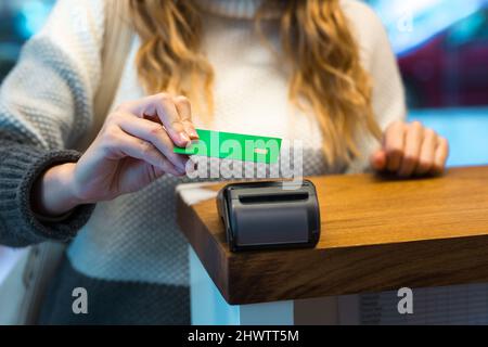 Frau, die über das Terminal mit Kreditkarte bezahlt Stockfoto