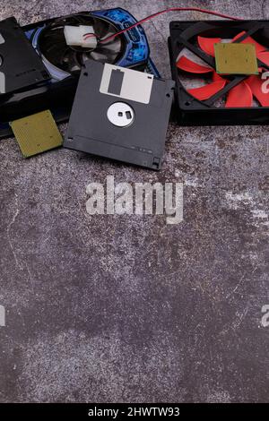 Technologischer Hintergrund, der von verschiedenen Komponenten des Computers auf einem Tisch mit einer Farbe ähnlich dem Zement und mit leerem Raum gebildet wird. Stockfoto
