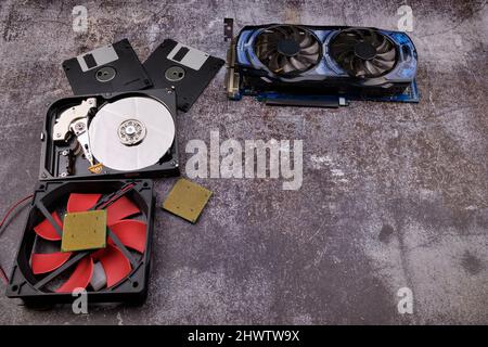 Technologischer Hintergrund, der von verschiedenen Komponenten des Computers auf einem Tisch mit einer Farbe ähnlich dem Zement und mit leerem Raum gebildet wird. Stockfoto