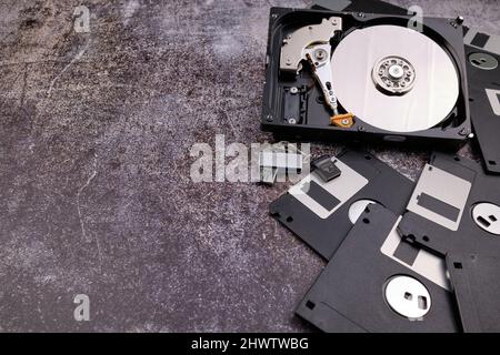 Technologischer Hintergrund, der von verschiedenen Komponenten des Computers auf einem Tisch mit einer Farbe ähnlich dem Zement und mit leerem Raum gebildet wird. Stockfoto