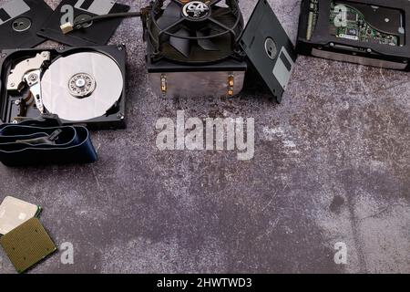 Technologischer Hintergrund, der von verschiedenen Komponenten des Computers auf einem Tisch mit einer Farbe ähnlich dem Zement und mit leerem Raum gebildet wird. Stockfoto