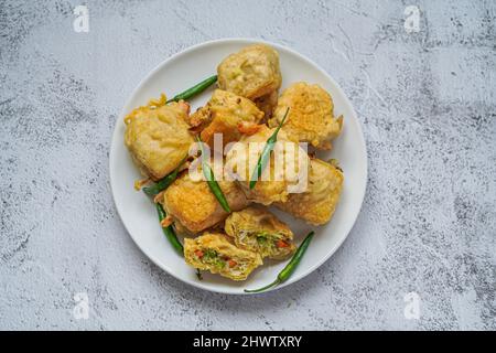 Indonesisches Street Food, gebratene Tofu gefüllt mit Gemüse (Tahu ISI) serviert mit frischem grünen Chili Stockfoto