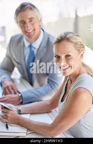 Sie sind eine starke Unternehmenskombination. Porträt zweier reifer Geschäftsleute, die sich von einem digitalen Tablet unterhalten. Stockfoto