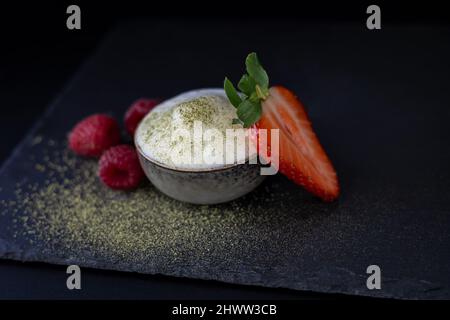 Matcha-Tee mit Milch serviert mit frischen Beeren Stockfoto